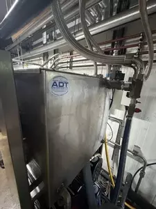 Rear view of custom stainless steel replacement tank installed on a Nilfisk Delta Booster multi-pump pressure washer system.